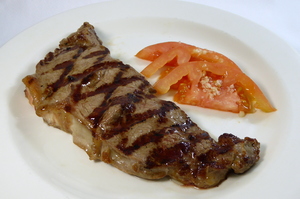 Grilled entrecôte with garlic and tomato salad