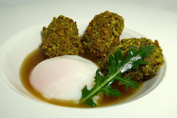 Chicken wings coated with pistachio crumbs and poached egg
