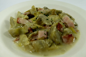 Artichokes stewed in green sauce with bacon
